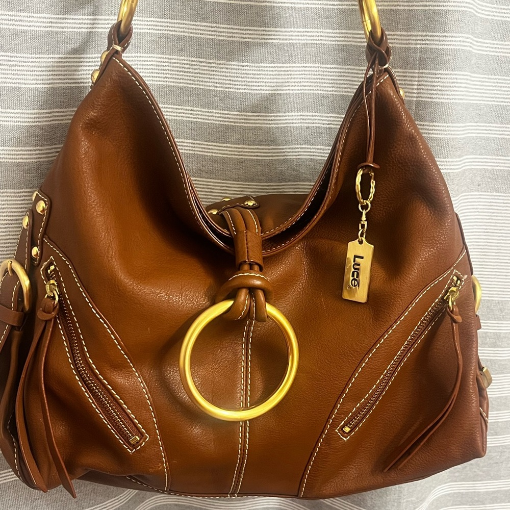 Shoulder bag with multiple pockets and one center zip pocket. 100% leather